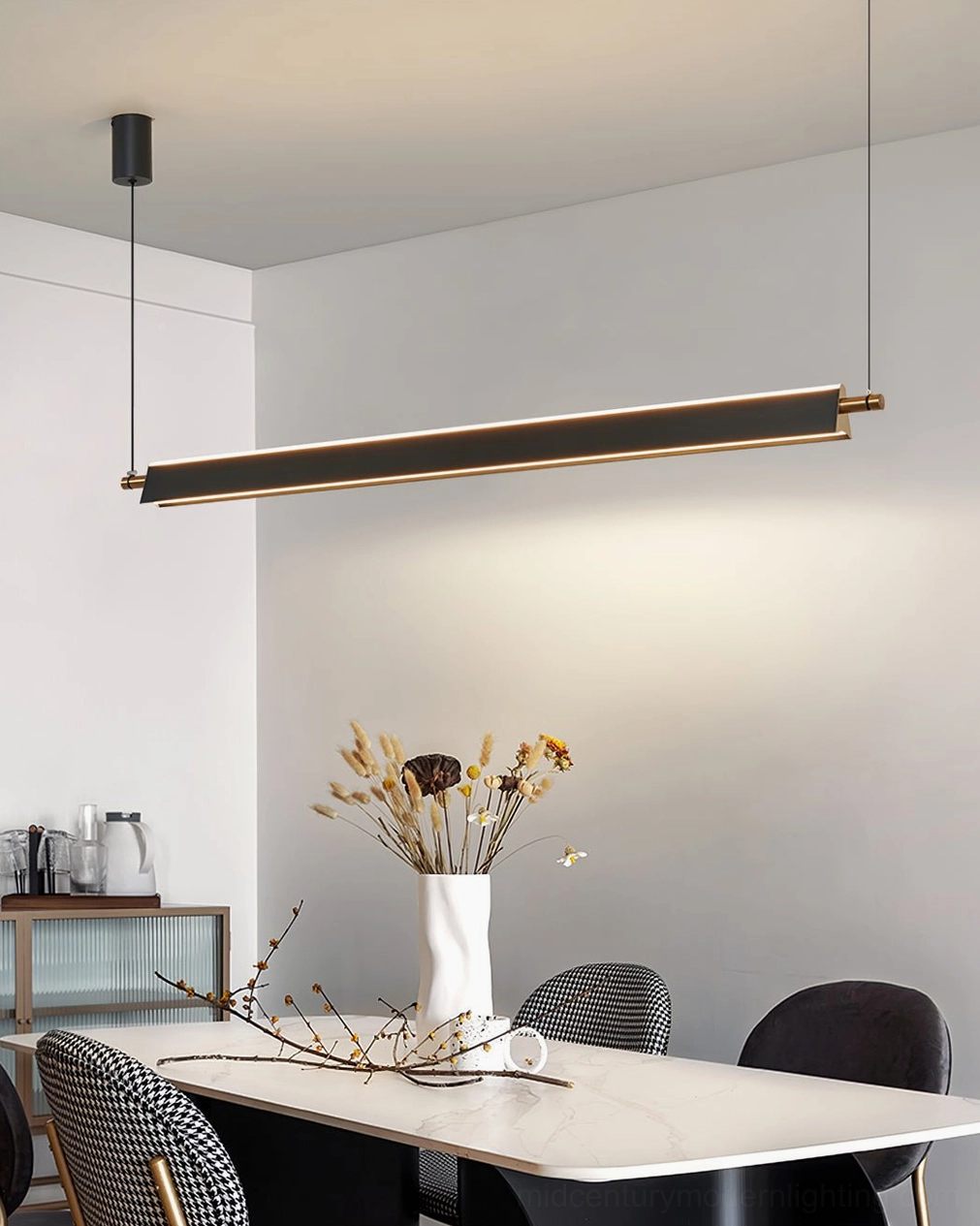 Compact modern linear chandelier with dual-tone black and gold finish suspended over white dining table