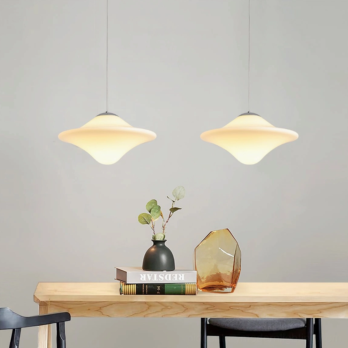 Twin pendant lights over console table in home entryway with decorative tabletop ornaments