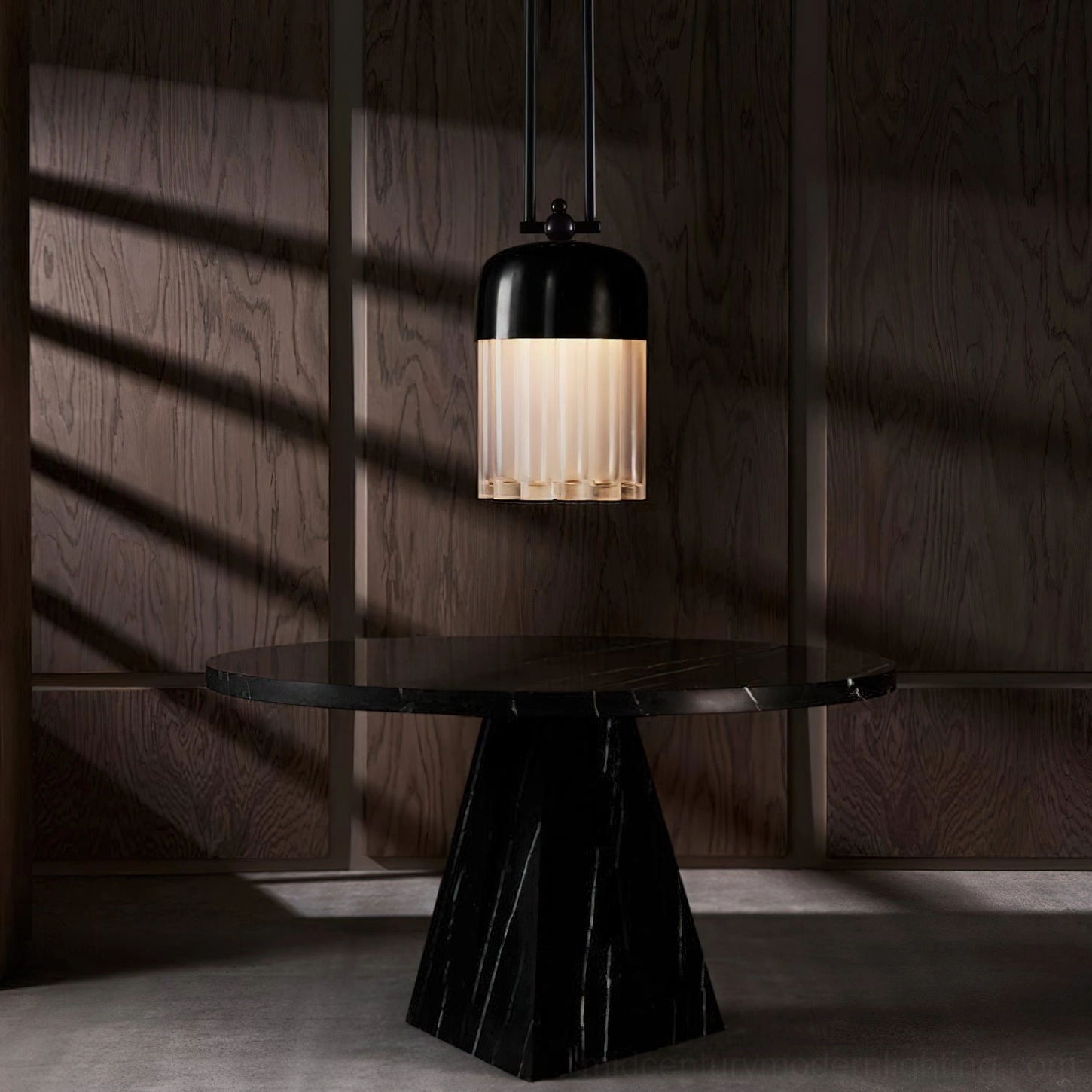 Black metal pendant light in dining nook, low-angle shot highlighting warm ribbed glass shade and matte canopy detail