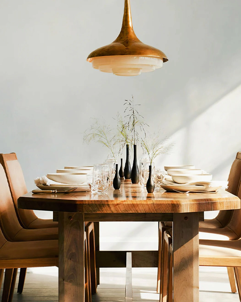 Tiered resin pendant fixture creating warm dining room lighting ambiance over wooden table