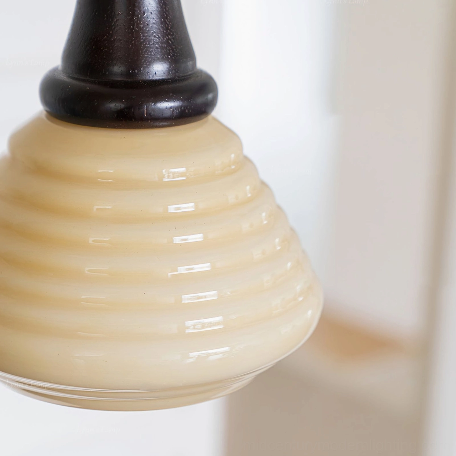 Close-up of wooden pendant light shade mounting showing dark wood collar connecting to rippled beige glass with artistic detail