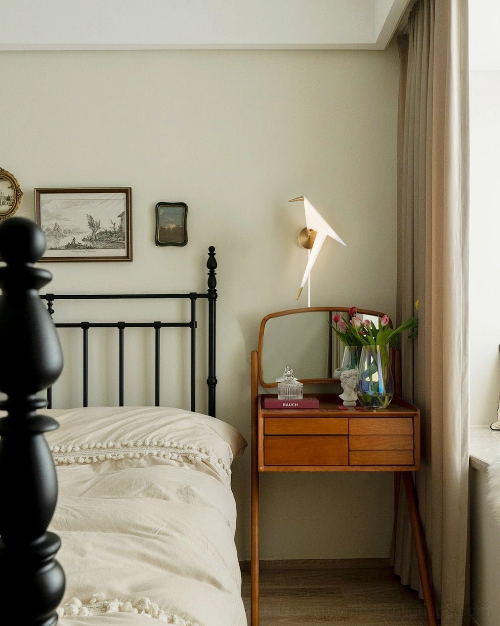 Perching Bird wall lamp with gold finish beside wooden vanity table in vintage Nordic bedroom style