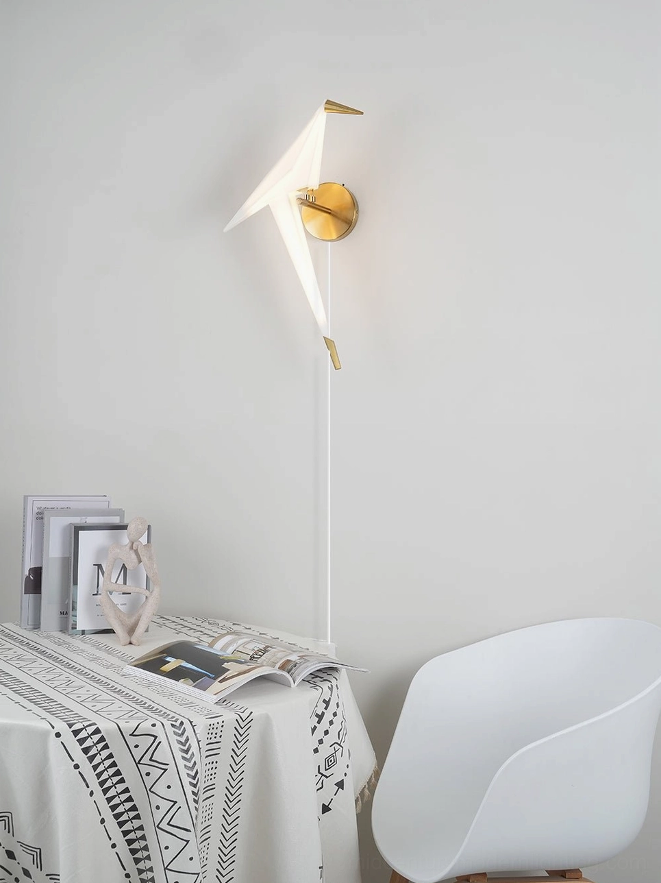 Perching Bird wall lamp illuminating home office desk with boho minimalist decor and accessories