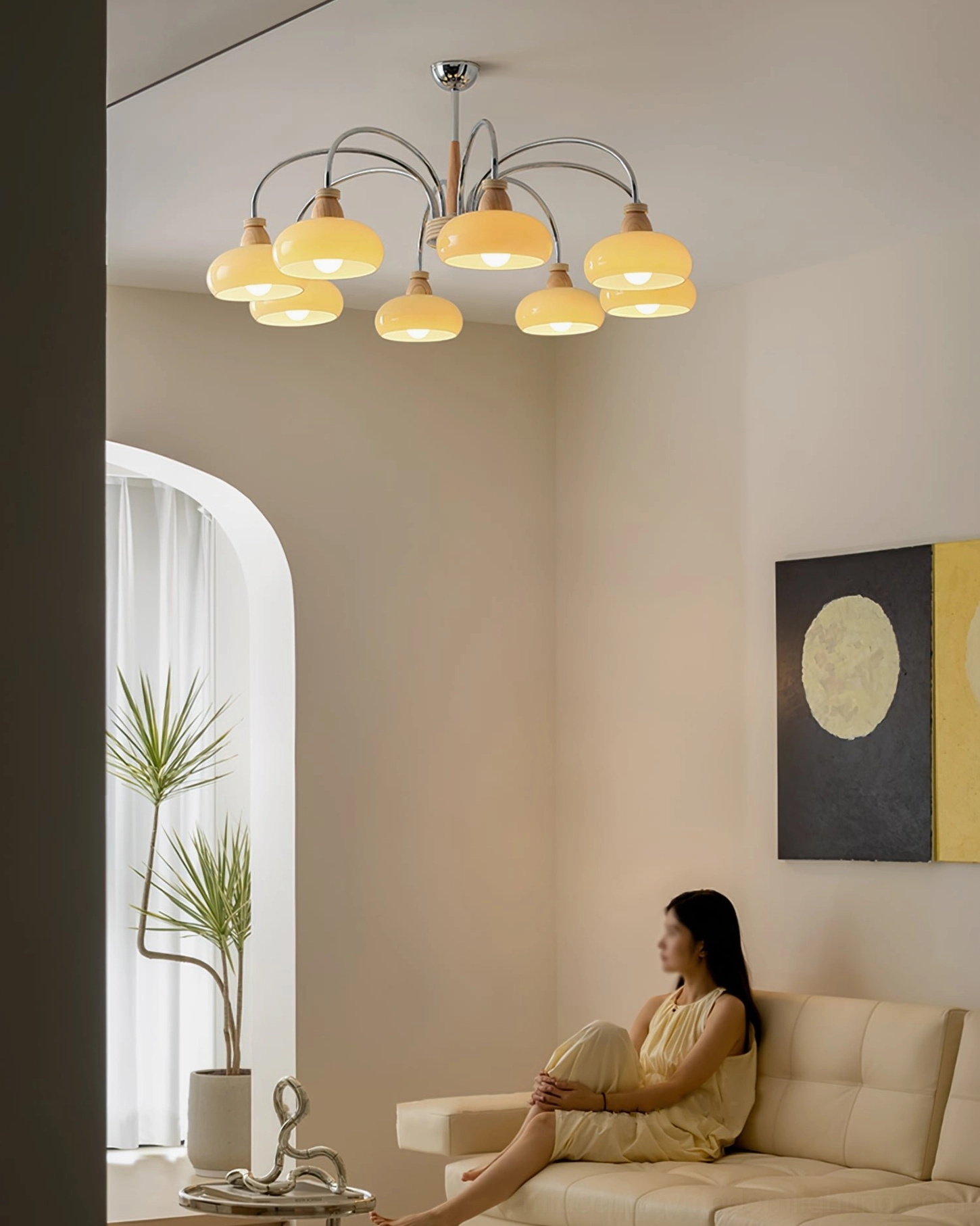 5-light pendant chandelier cozy nordic living room side view with woman in yellow, relaxing warm home vibe