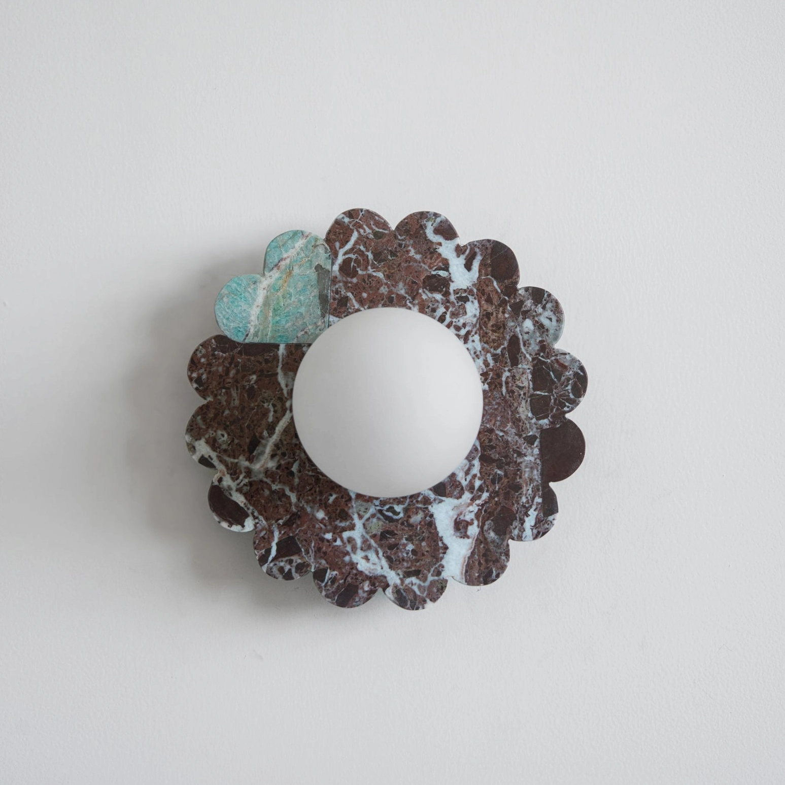 Red marble petal wall sconce with sculptural base and frosted glass shade studio shot