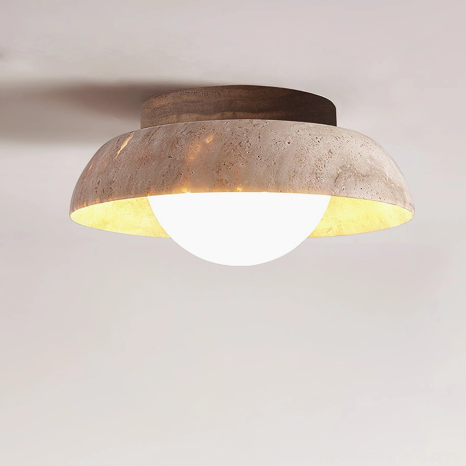 Close-up side view of Piedra ceiling light showing detailed travertine texture and warm inner glow on white background