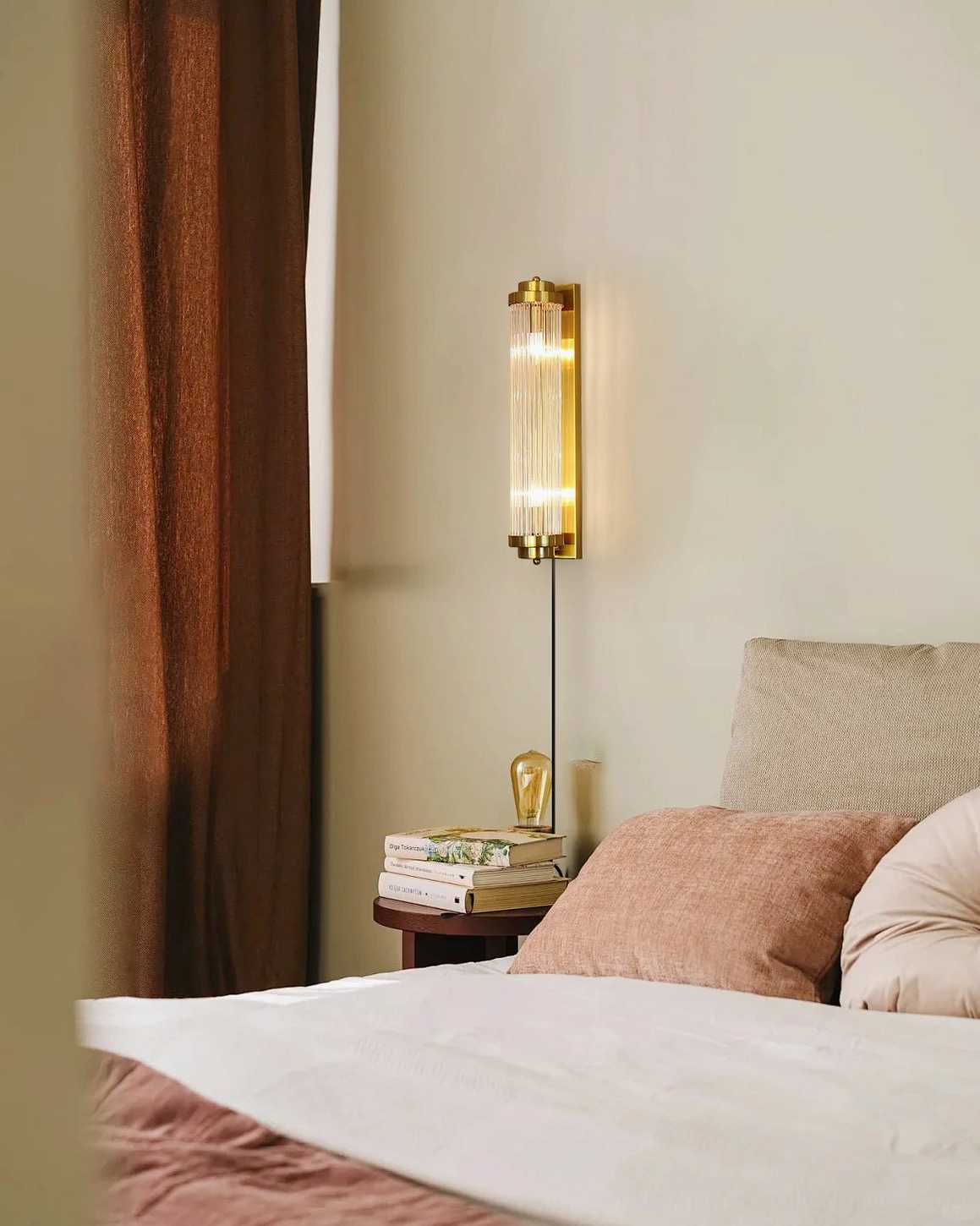 Cozy neutral bedroom interior featuring wall-mounted sconce in warm gold finish, home design aesthetic