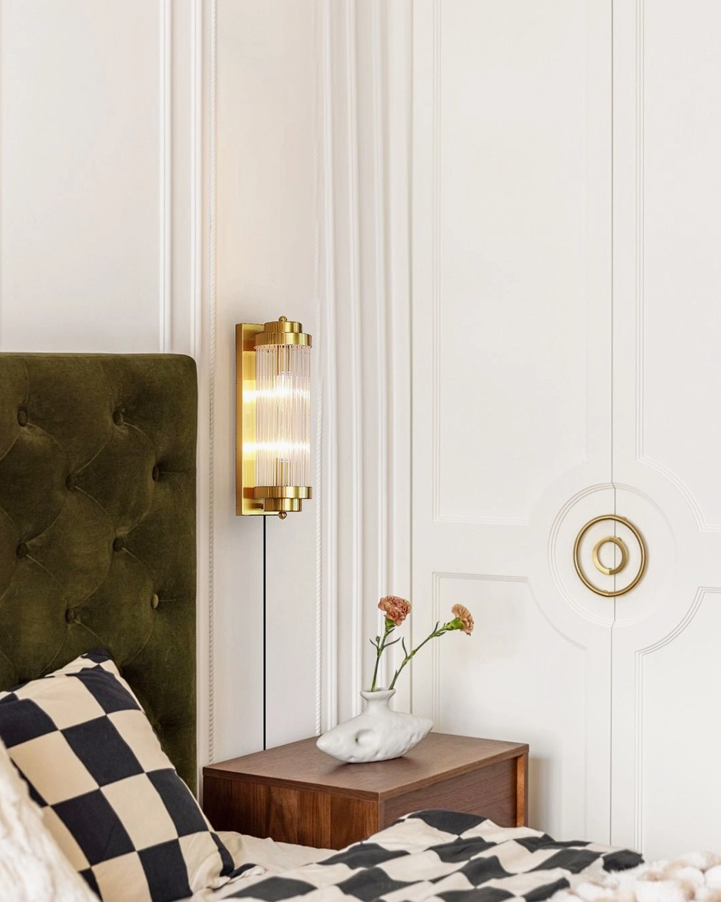 Modern minimalist bedroom with brushed gold wall sconce, ribbed glass shade detail in contemporary interior