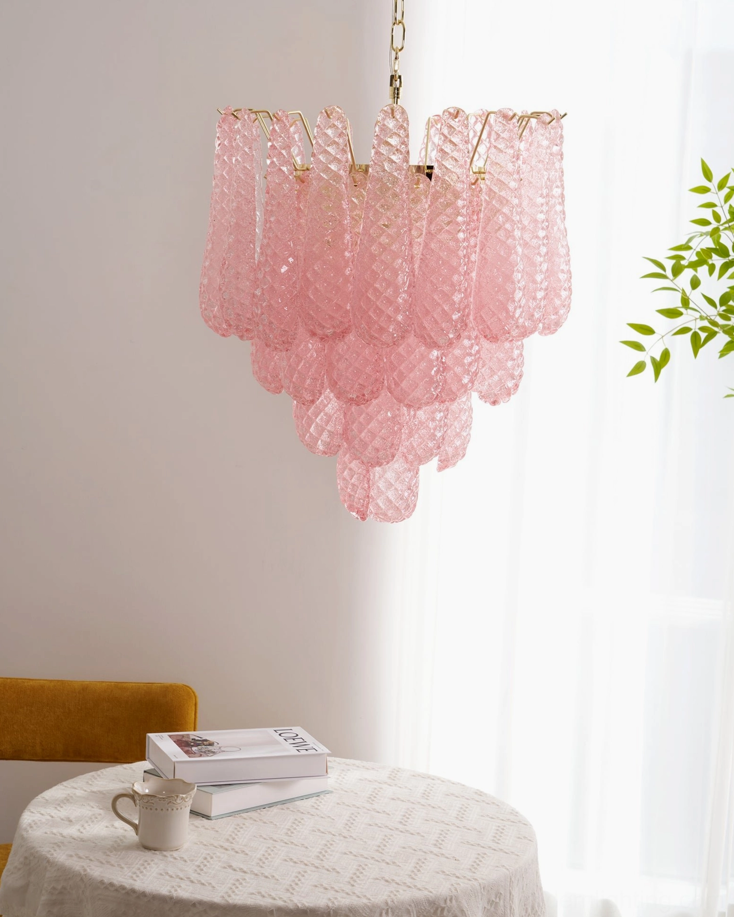 Pink glass chandelier installation view showing ceiling mounting and suspension chain