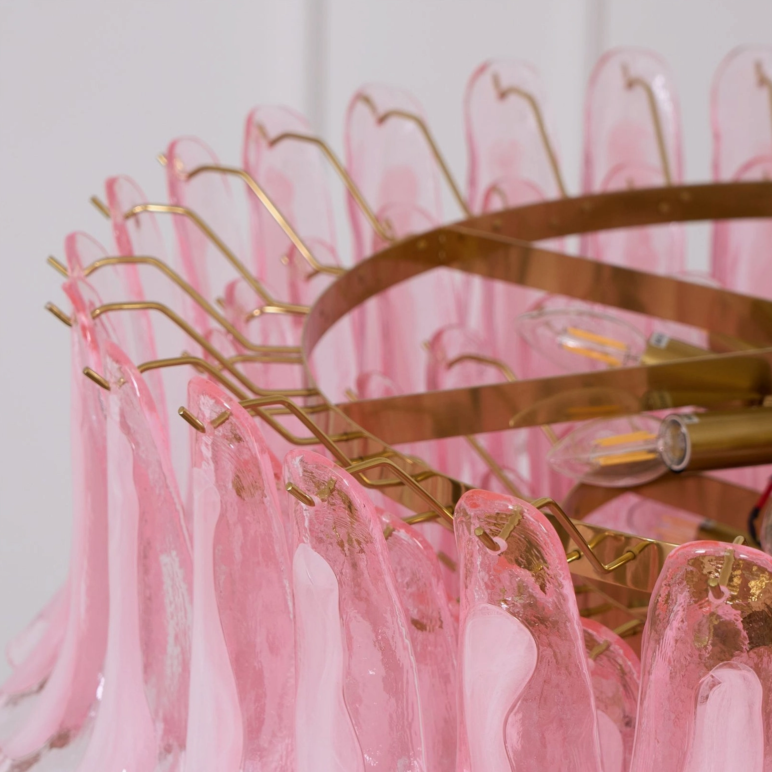 Pink Murano glass chandelier detail shot showing glass petal texture gradient and gold frame metalwork craftsmanship