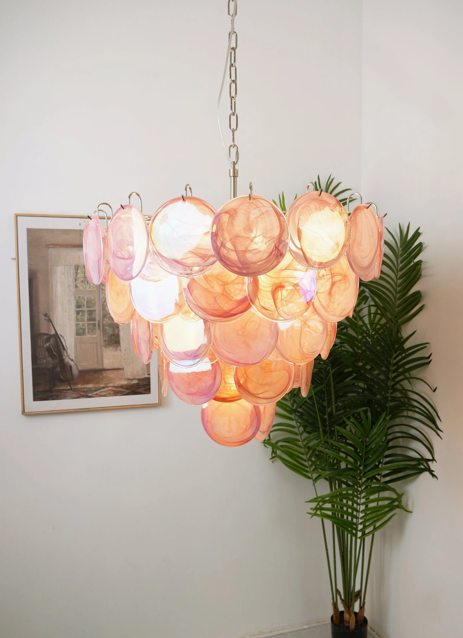 Pink Murano glass disc chandelier with romantic aesthetic, showing cascading glass discs and metal hanging chain in home interior