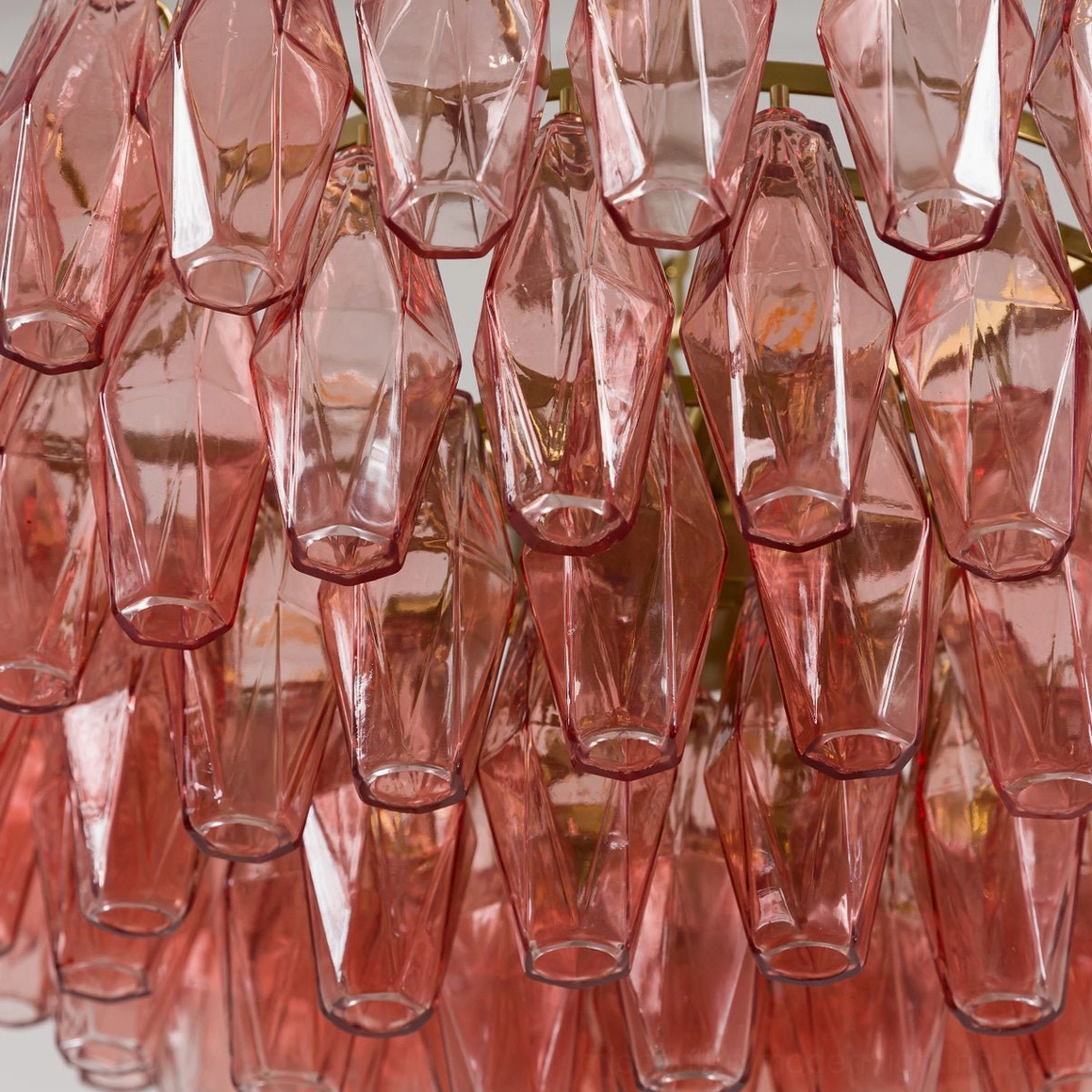 Pink polygon pendant chandelier installed as statement lighting fixture in contemporary interior space