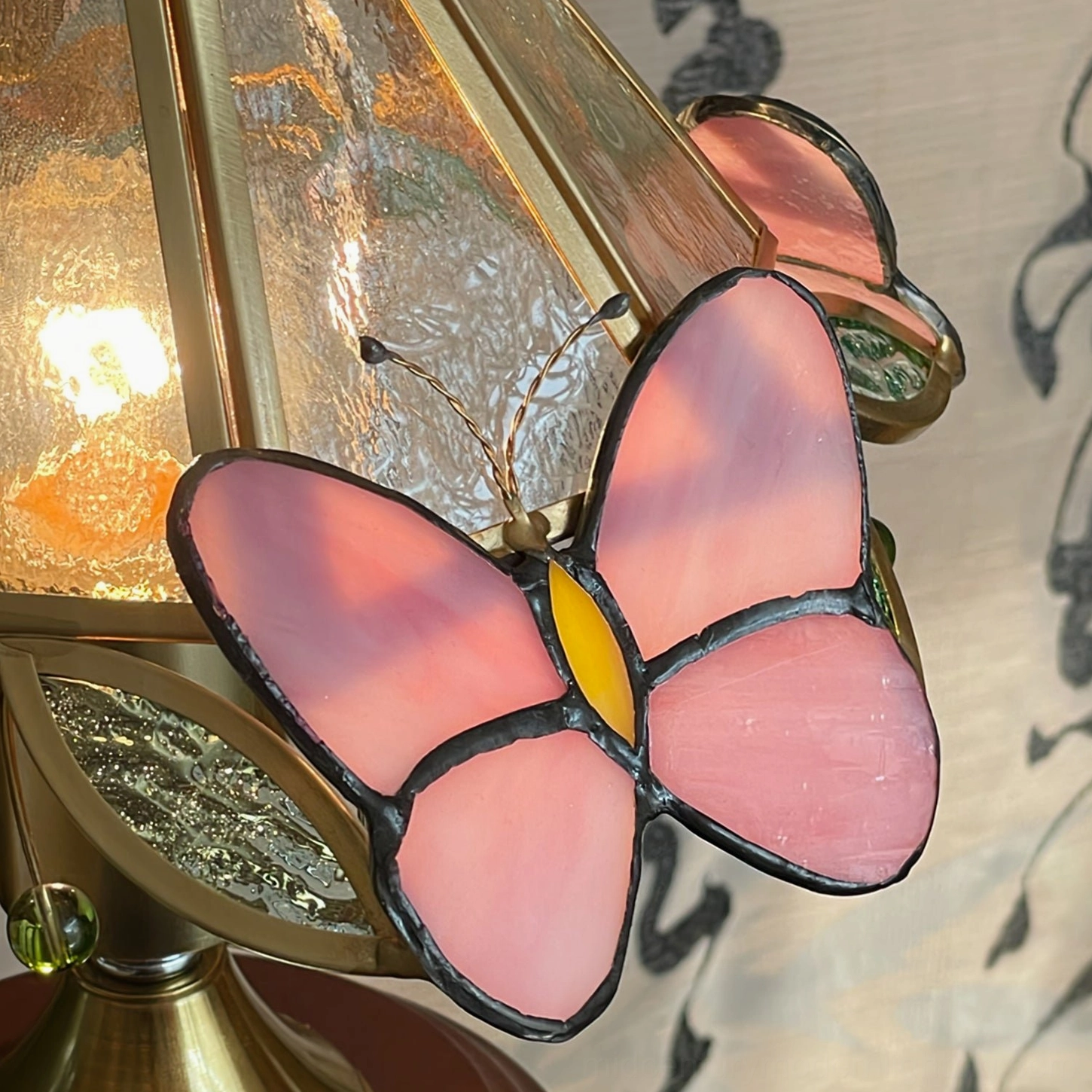 Detailed side view of pink stained glass butterfly on Jenny lamp with textured frosted glass finish