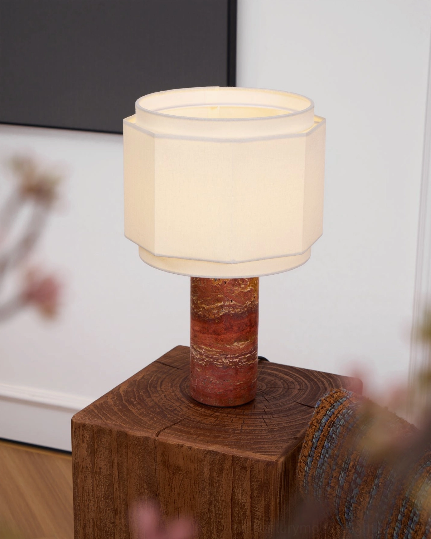 Pipito table lamp styled with natural botanicals and blurred floral foreground on wood stump table