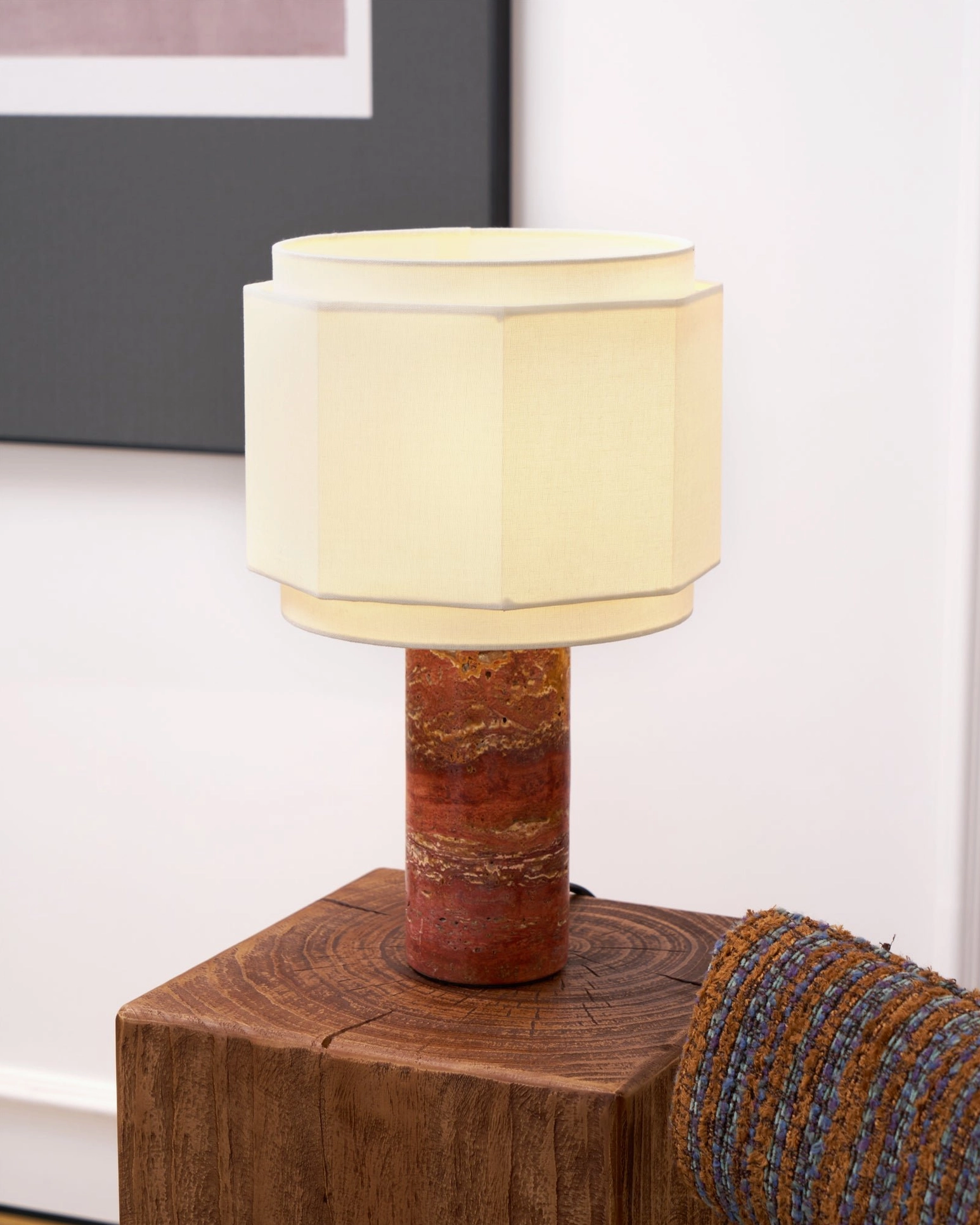 Pipito red travertine base table lamp with off-white fabric shade in scandinavian minimalist setting