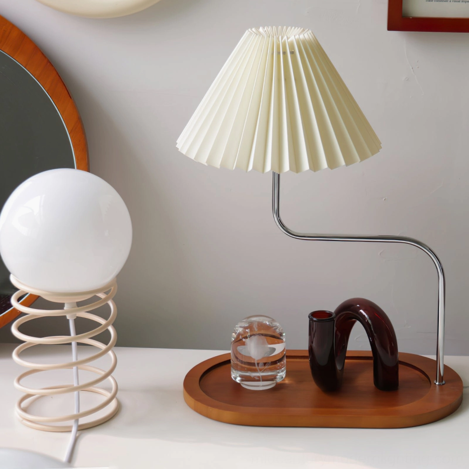 Three-quarter front view of pleated fabric table lamp with walnut tray on vanity table