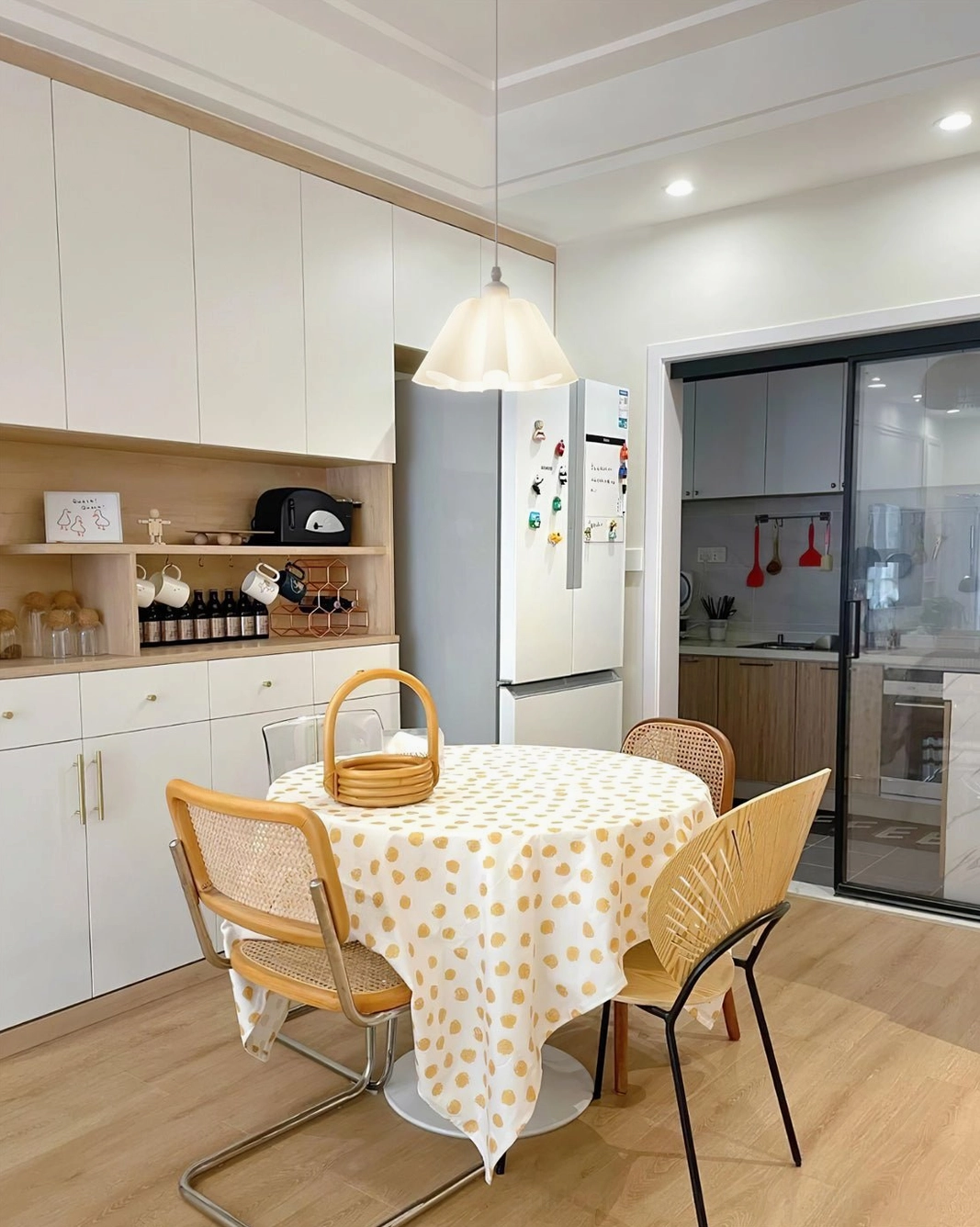 Modern pleated pendant lamp illuminating kitchen dining space with light wood tones and minimalist aesthetic
