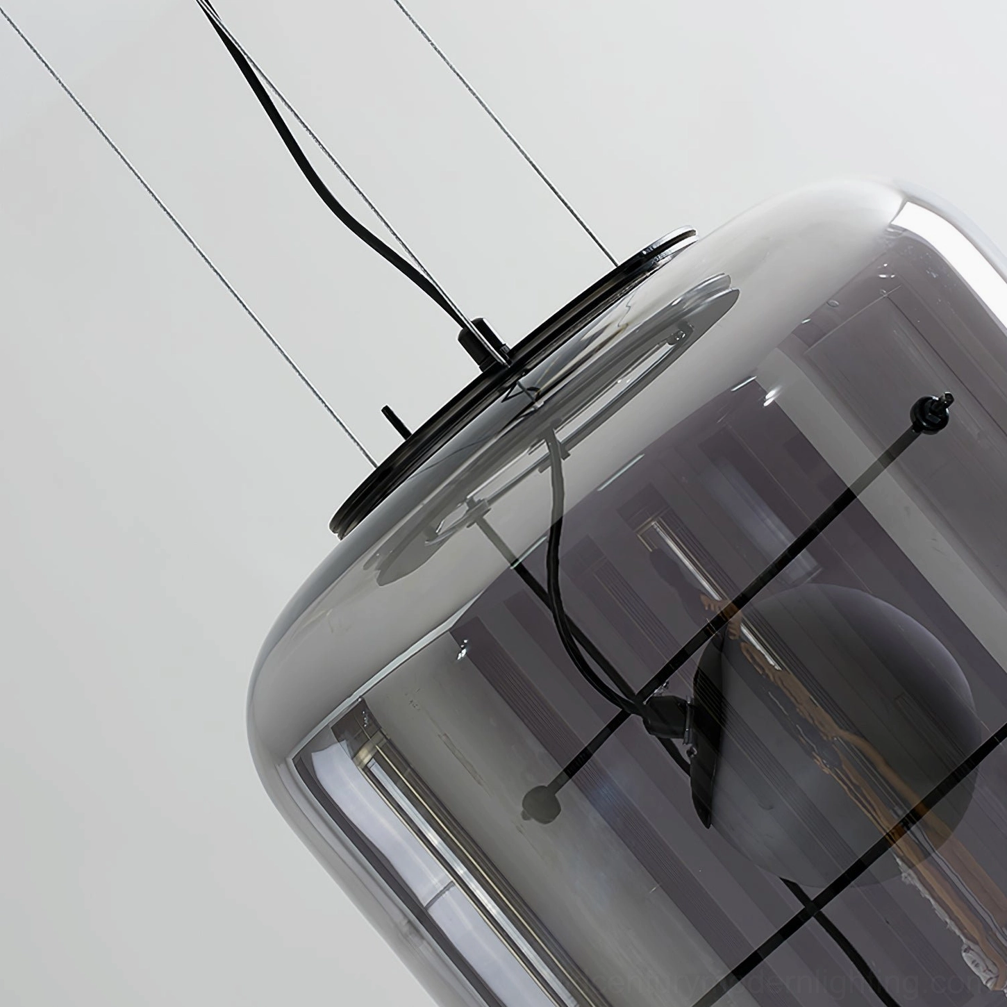Plot pendant light fixture with smoke grey glass and black iron frame in contemporary space