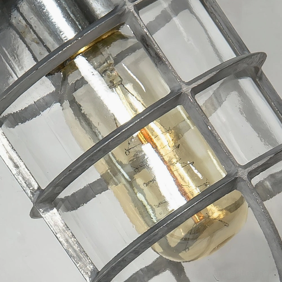 Macro close-up of Porto wall sconce showing metal grid cage construction and Edison bulb detail