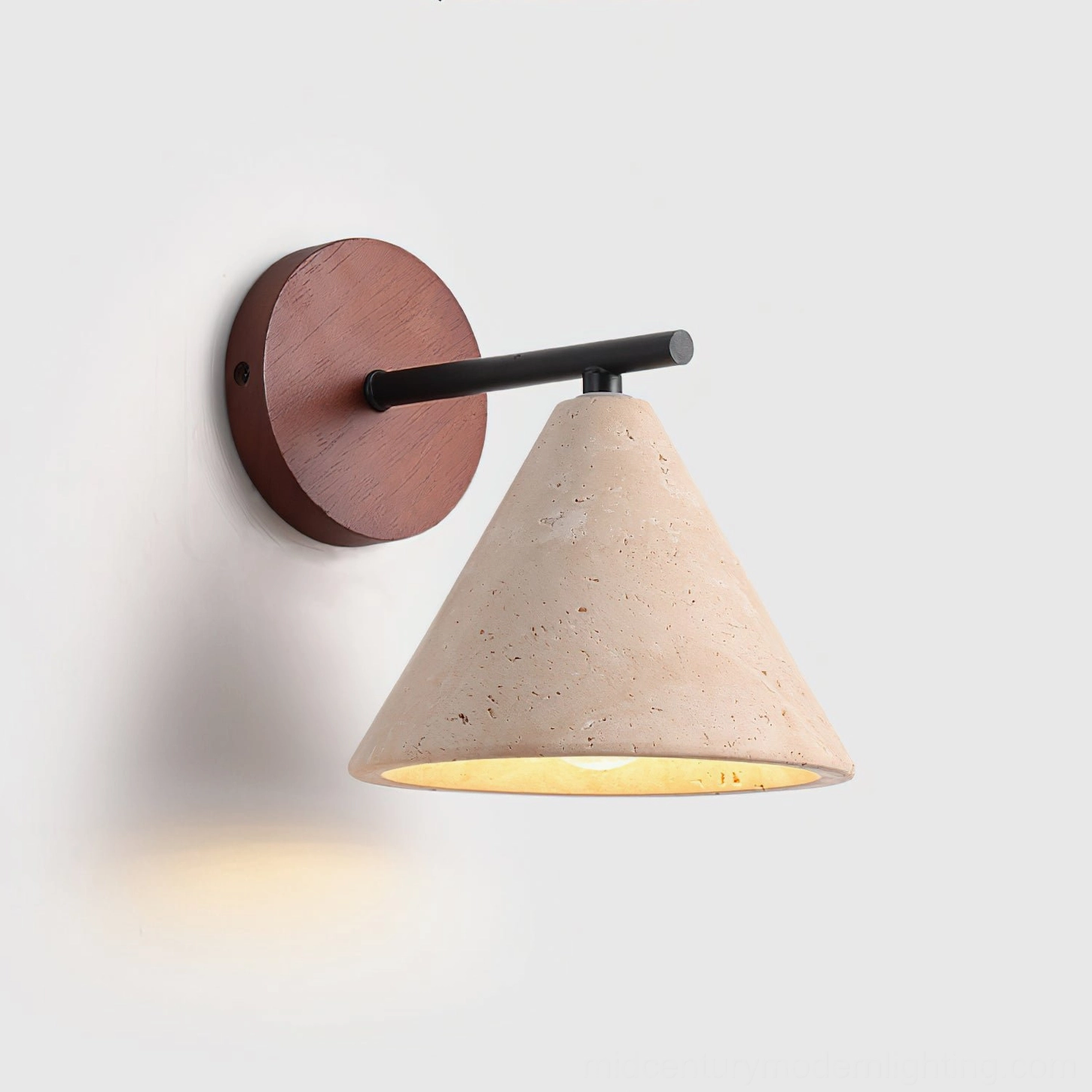 Possio wall sconce illuminated, demonstrating warm ambient glow diffused through travertine stone in minimalist setting