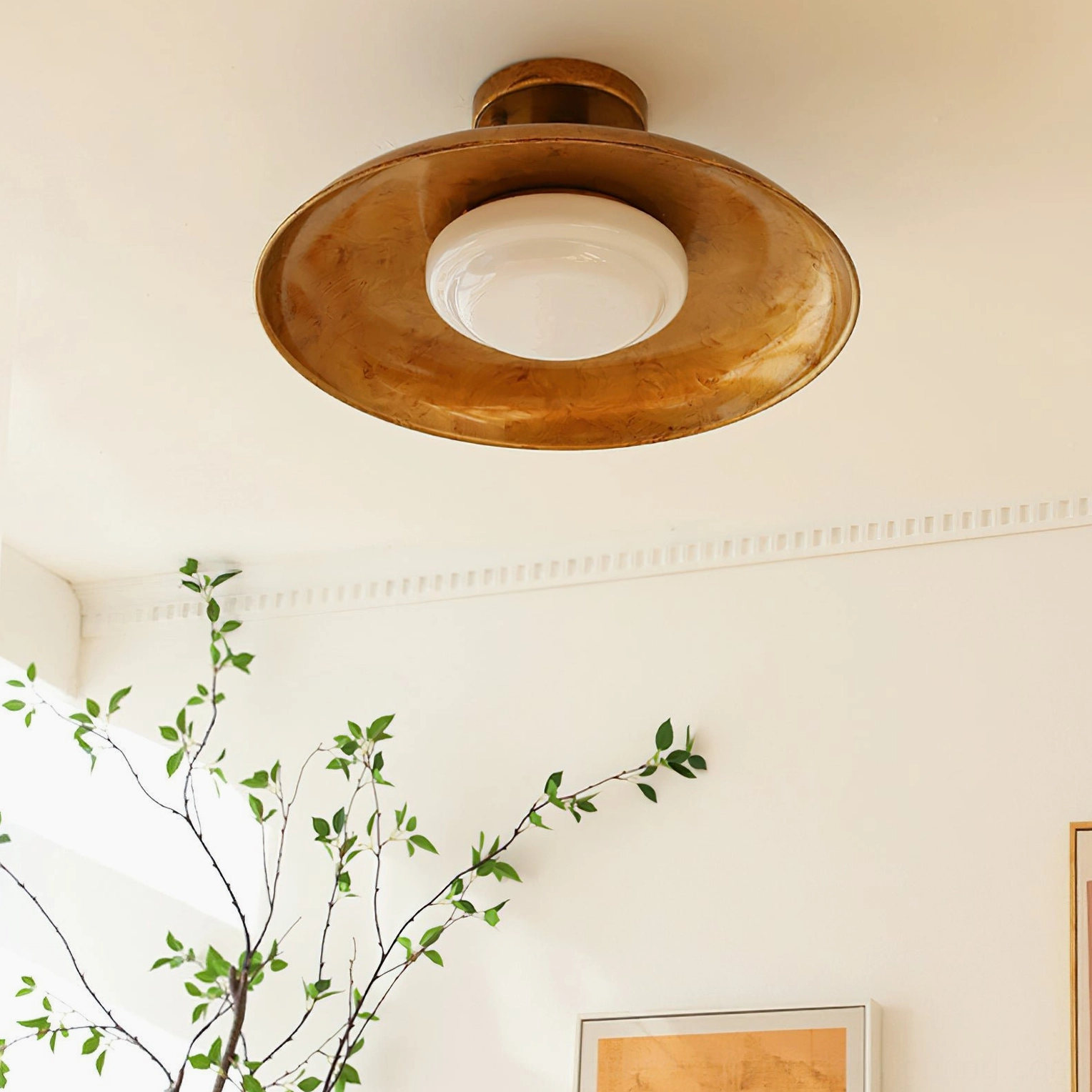 Side profile close-up showing brass finish and smooth white opal glass diffuser of ceiling fixture