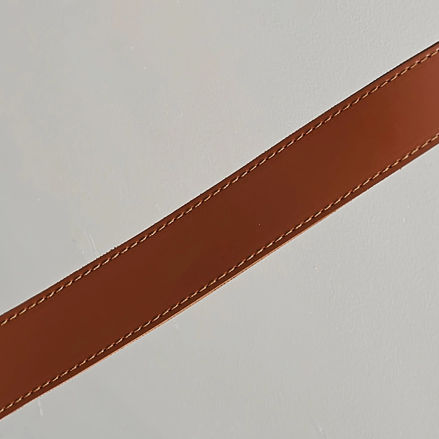 Premium cognac brown leather strap close-up displaying fine stitching seams and rich leather patina finish
