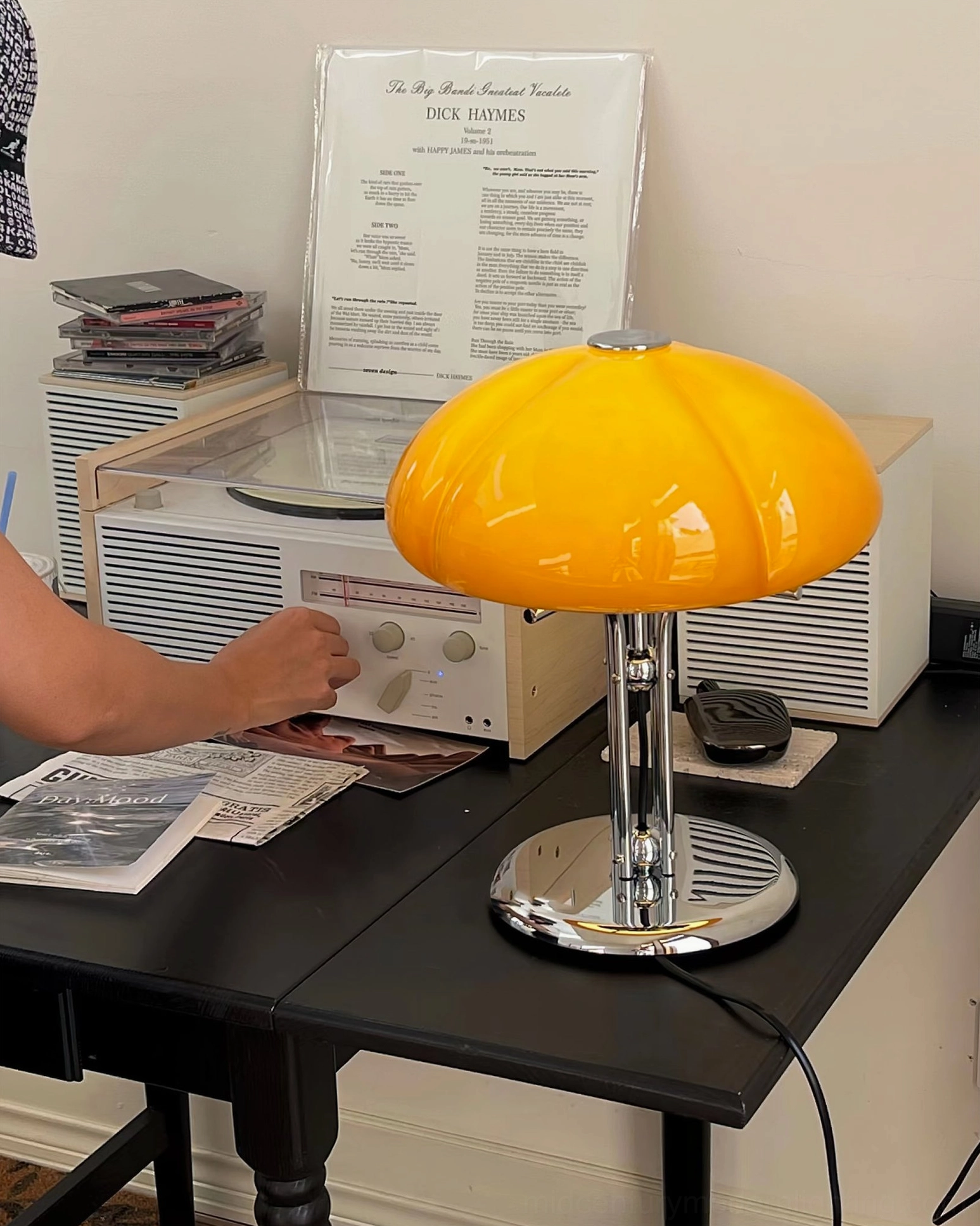 Quadrifoglio pumpkin table lamp with bright yellow amber glass shade on home office black desk, retro workspace styling with hand visible