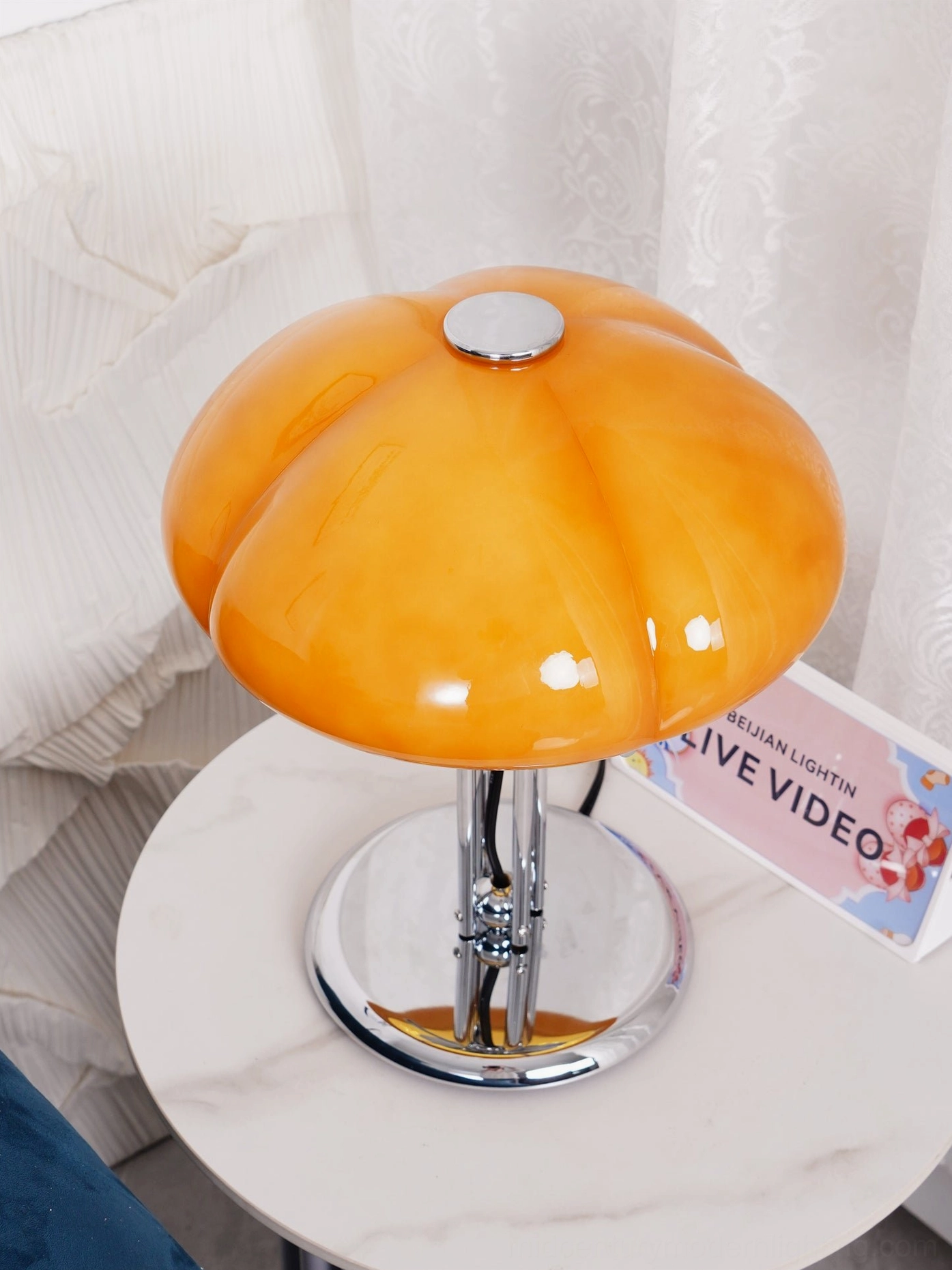 Quadrifoglio orange glass table lamp three-quarter view, showing curvaceous four-leaf silhouette and warm amber tone