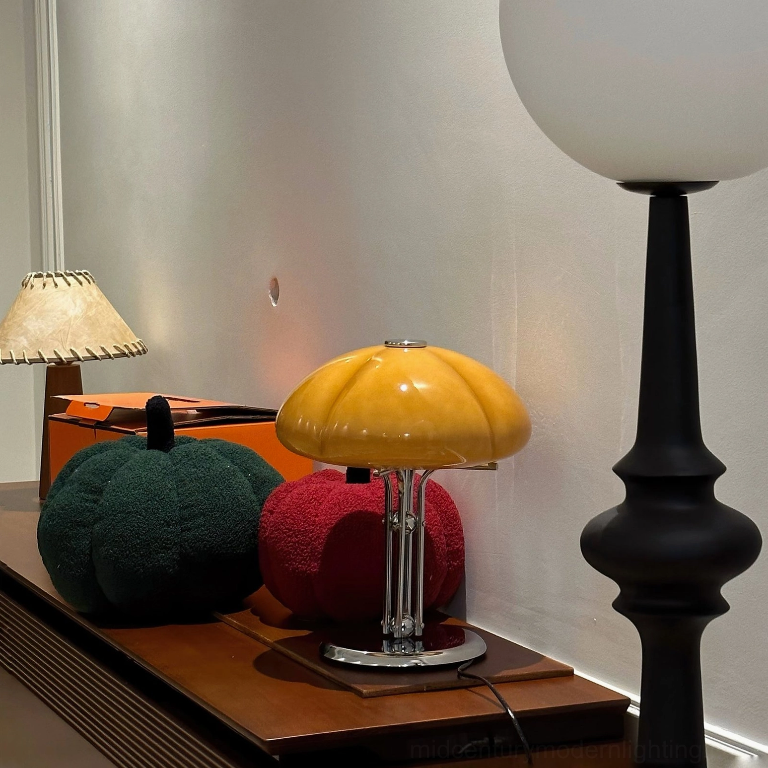 Quadrifoglio orange glass table lamp three-quarter studio angle, showing sculptural four-leaf form and integrated LED