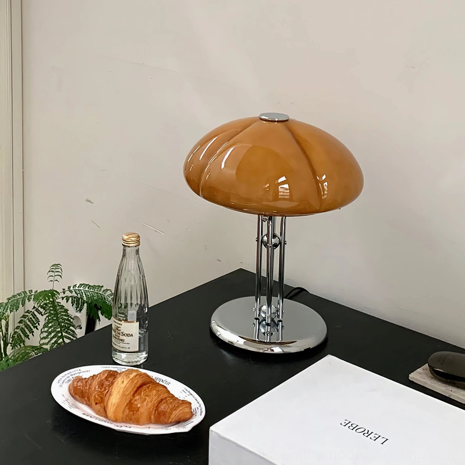 Quadrifoglio table lamp hero shot studio lighting, showcasing hand-shaped amber glass shade and polished chrome hardware