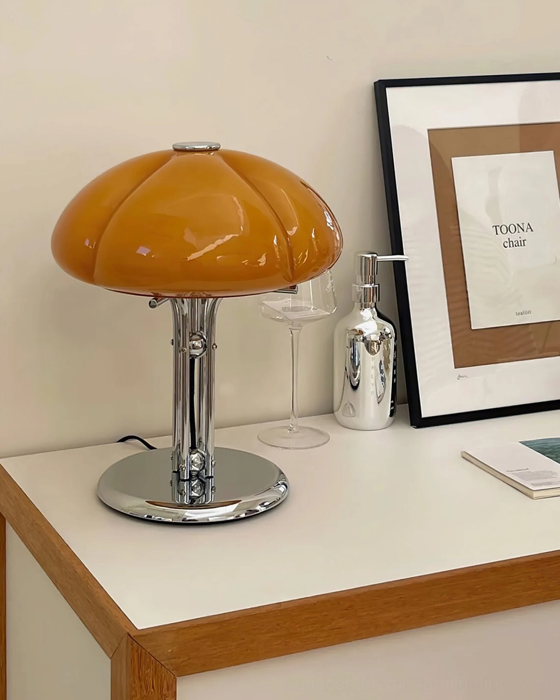 Quadrifoglio four-leaf clover lamp on vanity side table with decorative glassware and art frame, three-quarter front angle