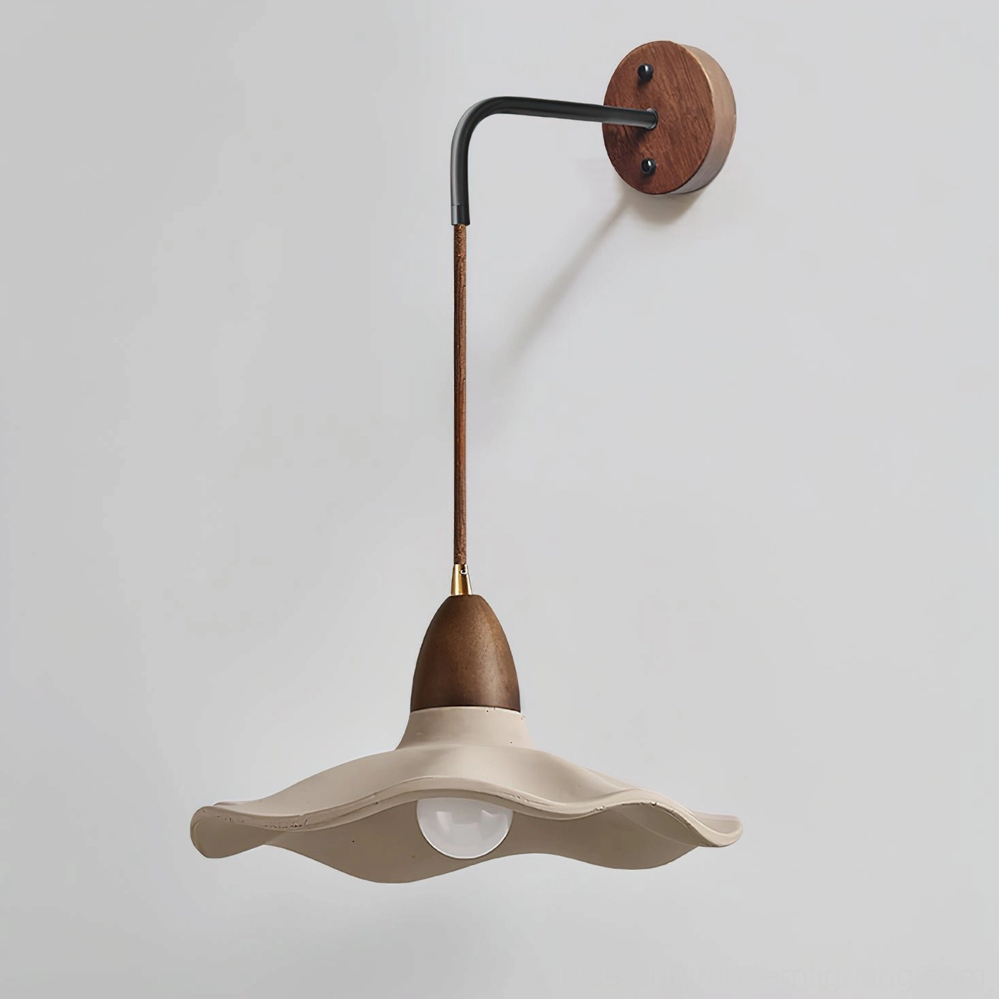 Close-up detail view of Radha wall lamp showing concrete wave pattern, exposed bulb, and walnut wood fixtures