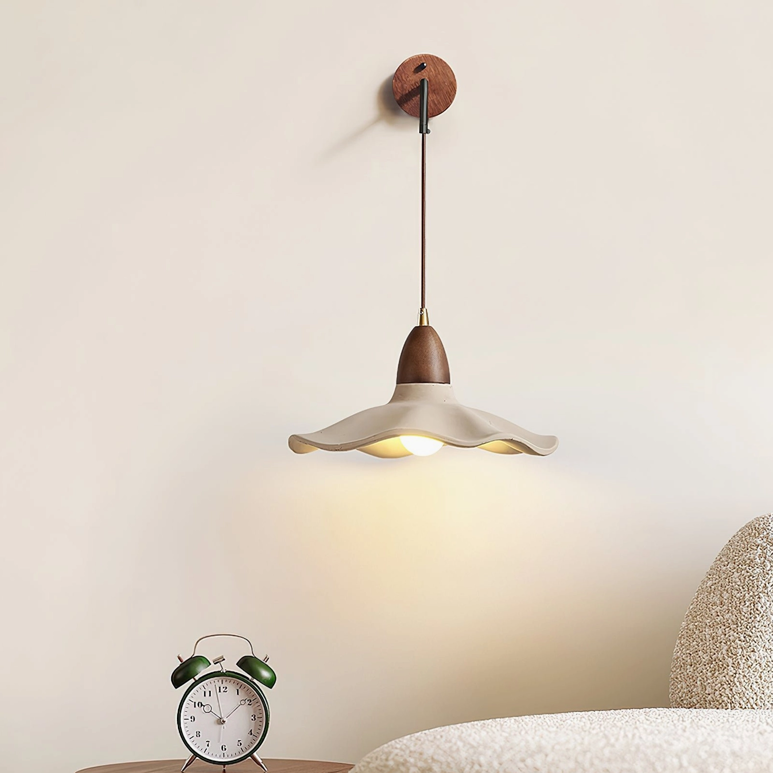 Radha sculptural wall lamp in modern living room beside sofa with clock, neutral Nordic home style