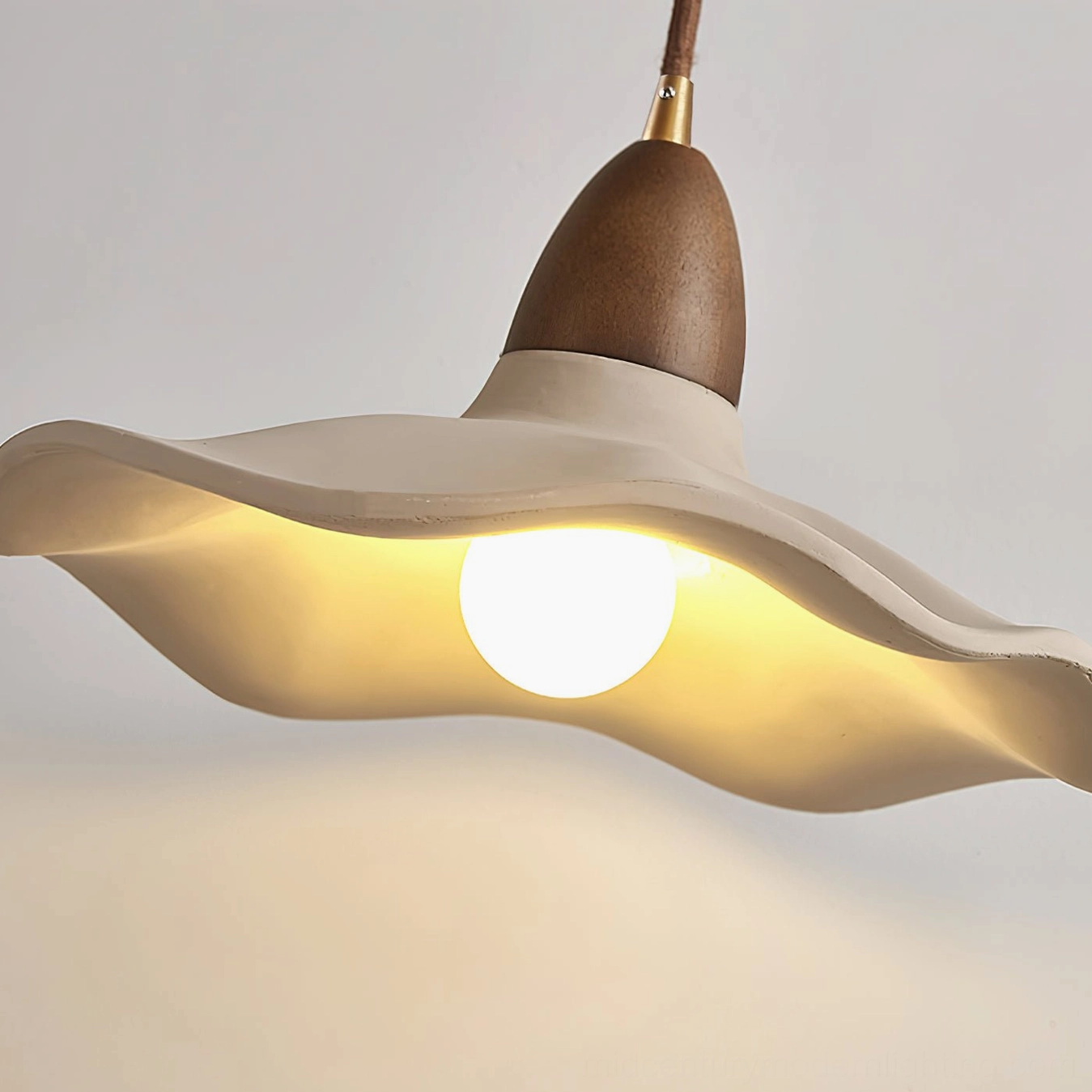 Radha organic modern wall lamp showcasing sculptural concrete shade design with soft ambient glow
