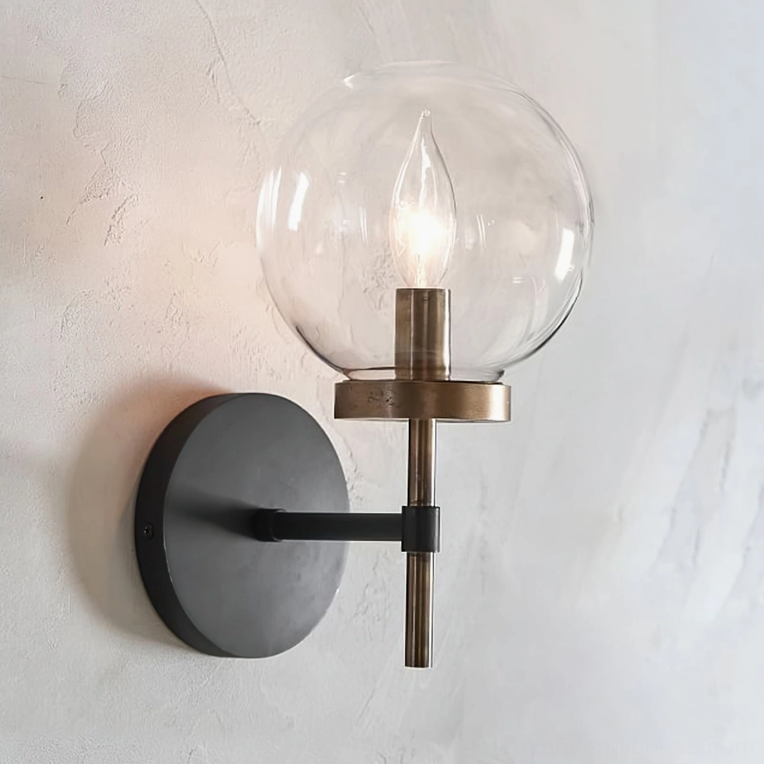 Ralbay illuminated globe wall light mounted on concrete wall with warm candlelight glow, close-up perspective