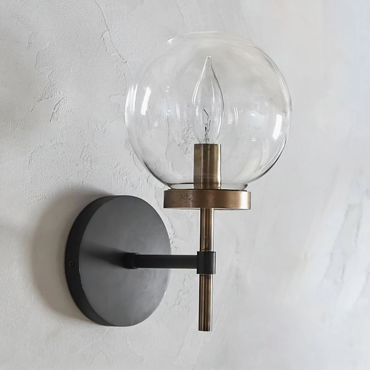 Ralbay unlit globe wall sconce on textured concrete wall showing exposed E14 bulb socket and minimalist modern design
