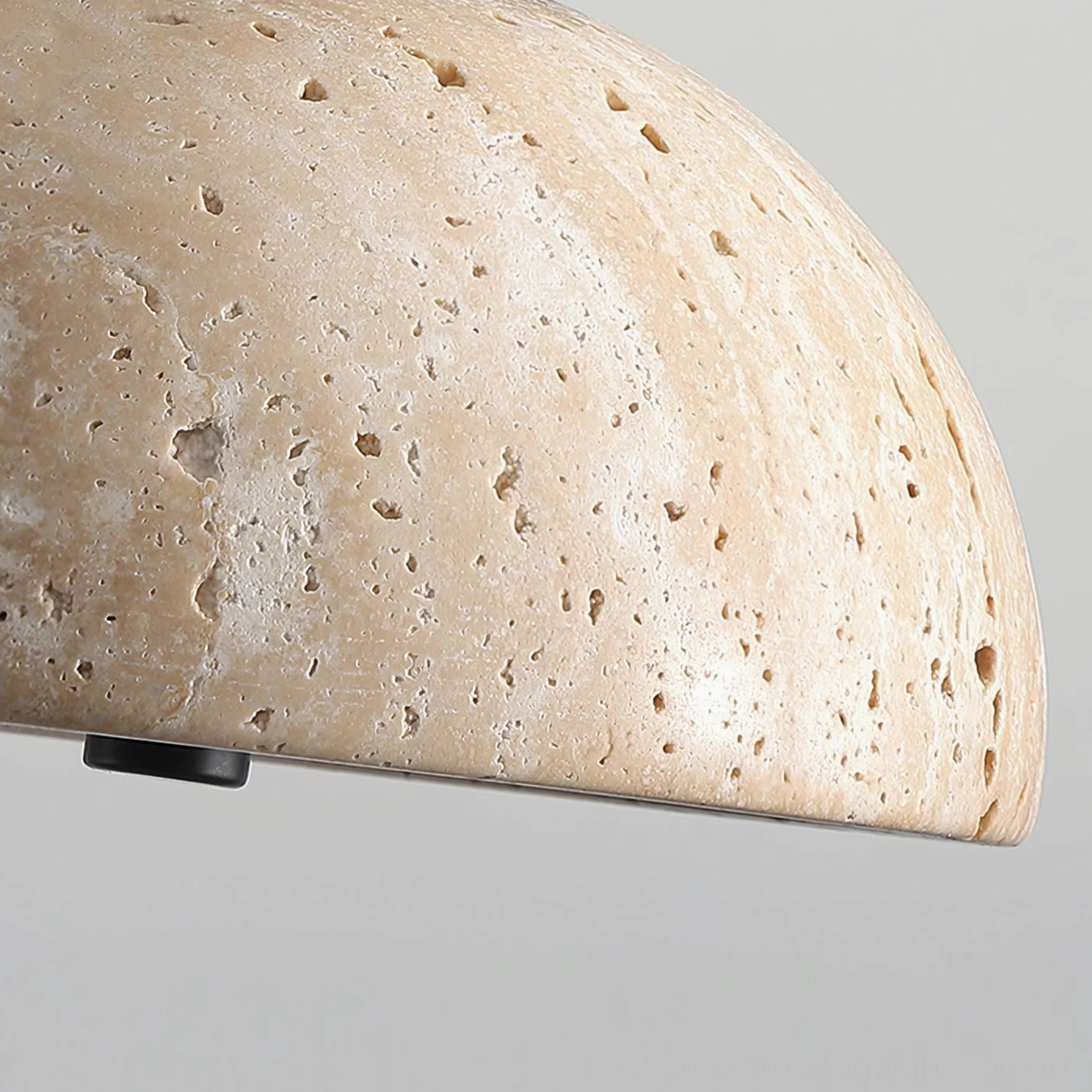 Bottom view of Randolf travertine pendant lamp shade displaying natural porous stone texture and black metal mounting base