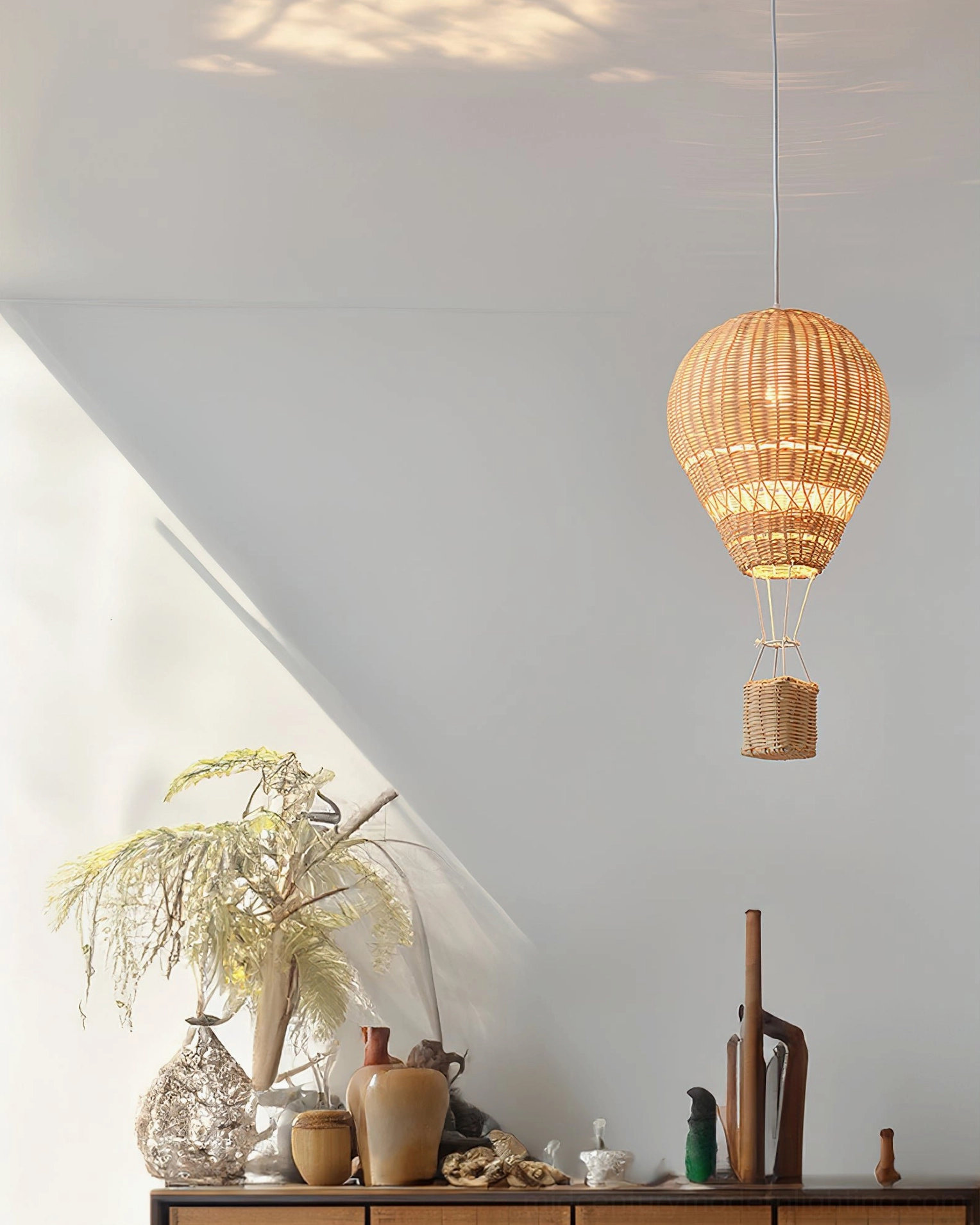 Hot air balloon rattan pendant fixture with Edison bulb creating shadow patterns through weave