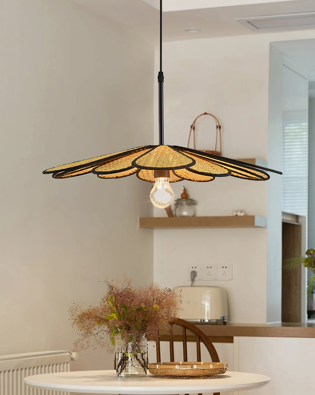 Handwoven rattan flower pendant above small kitchen dining corner with dried flowers, wooden shelf and warm lighting