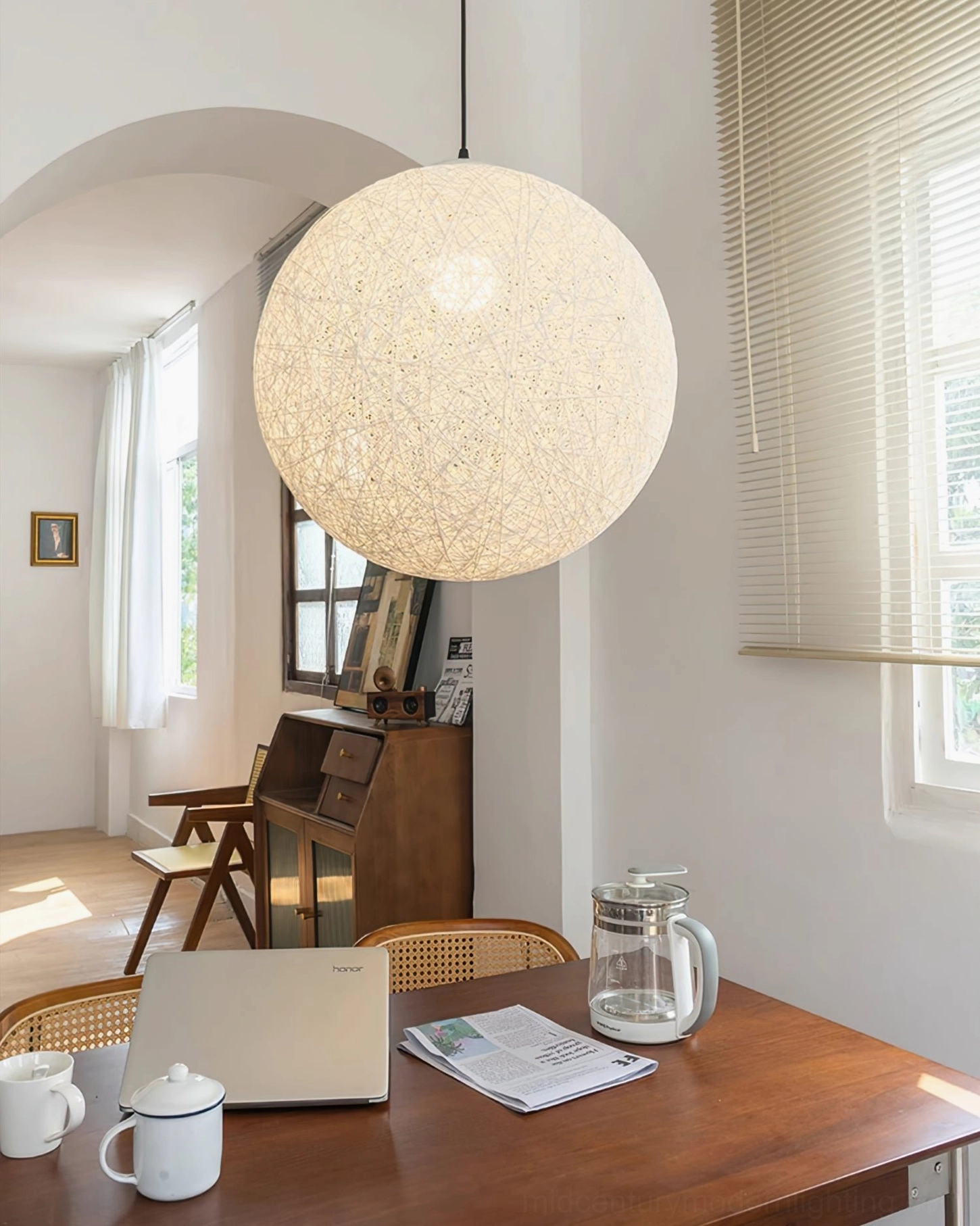 Natural rattan globe pendant light sunlit arched dining area minimalist home decor