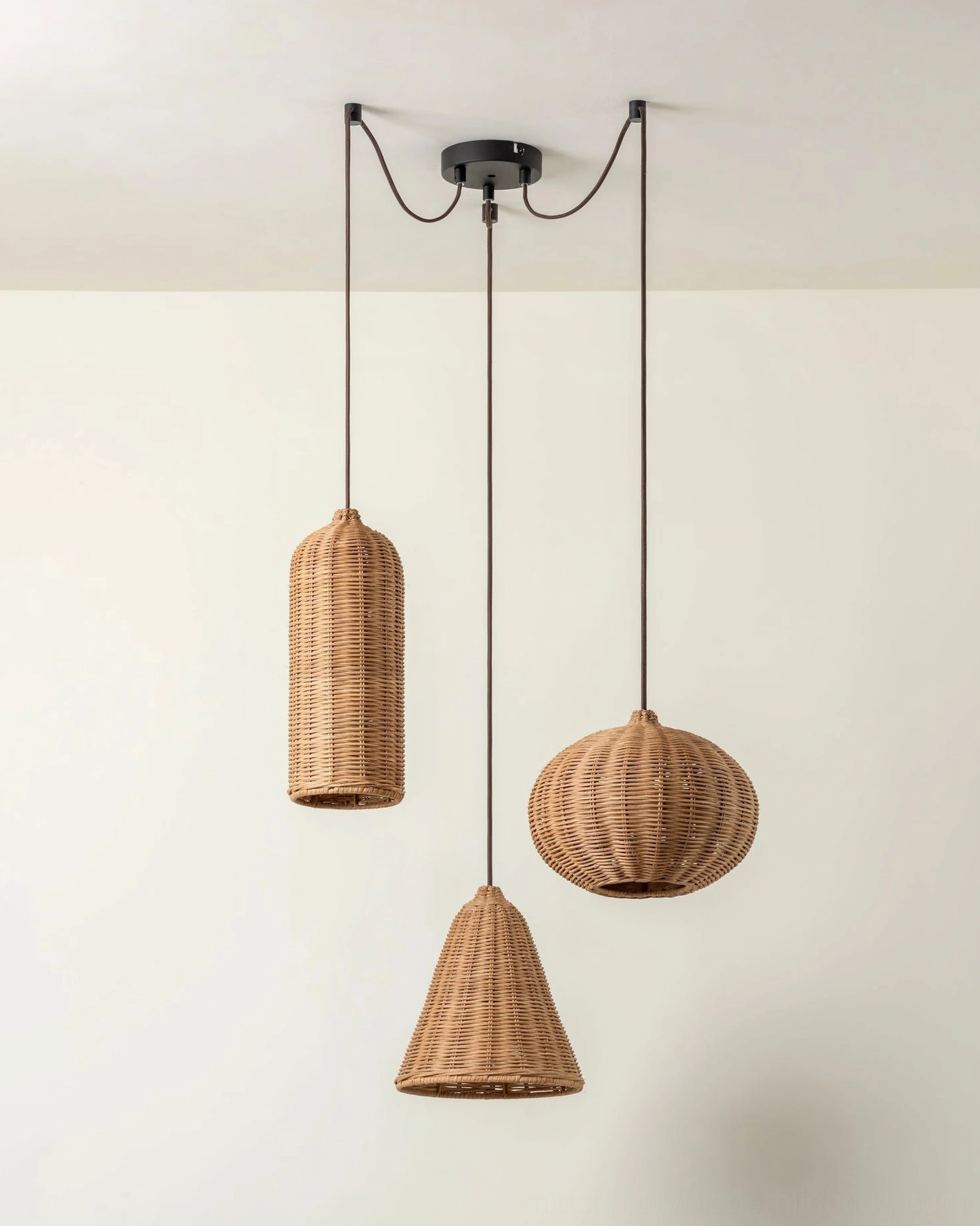Rattan pendant light cluster arrangement showing mixed shade sizes and heights for dramatic interior impact