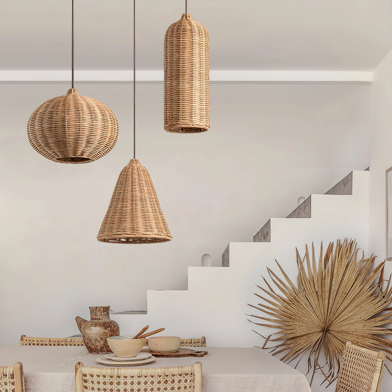 Assorted hand-woven rattan pendant lamps hanging in dining space beside staircase, showing three unique woven shade designs
