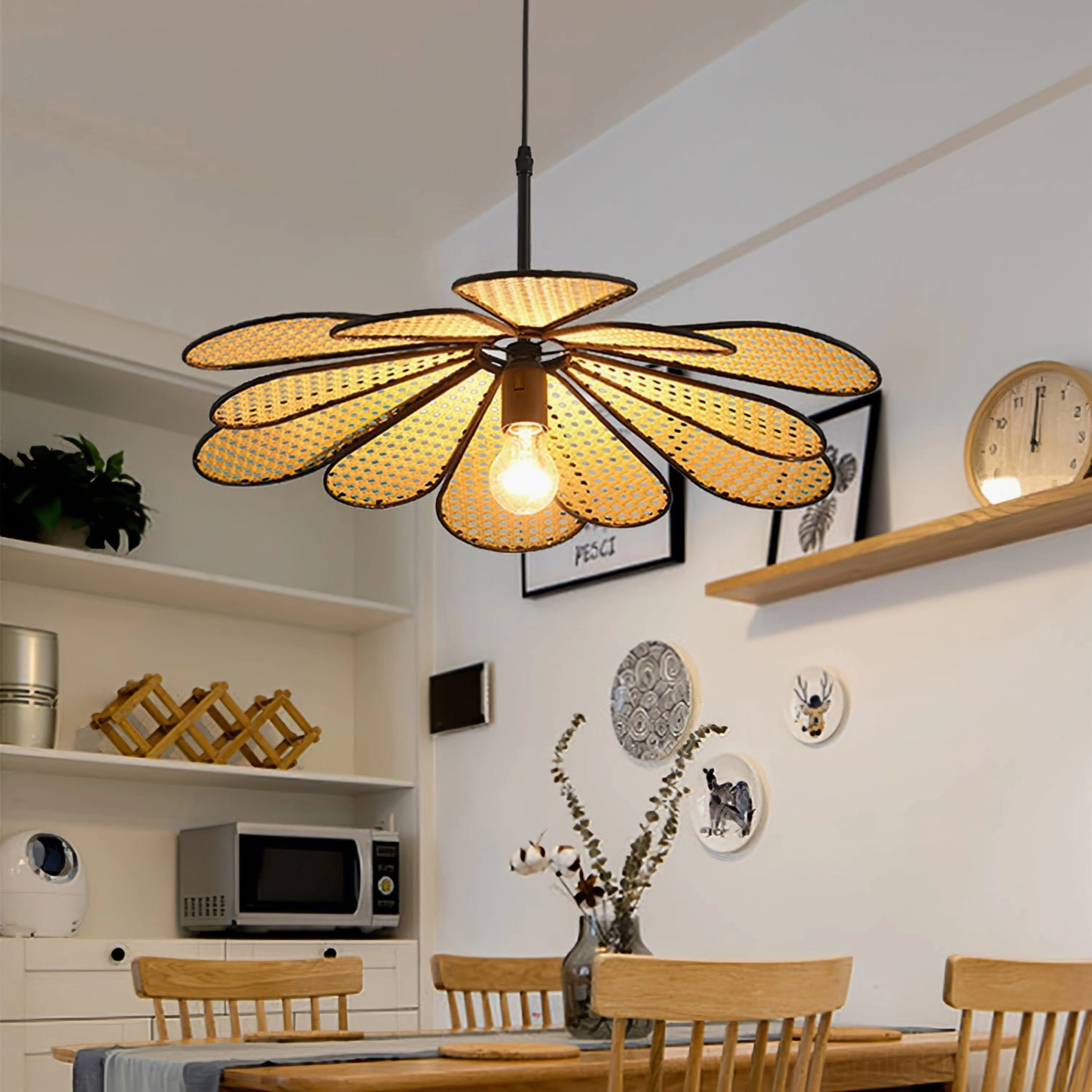 Rattan flower pendant light in open kitchen dining area with floating shelves, decorative wall clocks and art prints