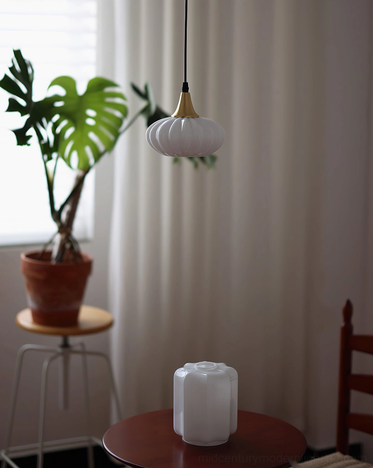 Rayburn ribbed glass pendant light in casual retro dining nook with monstera plant decoration