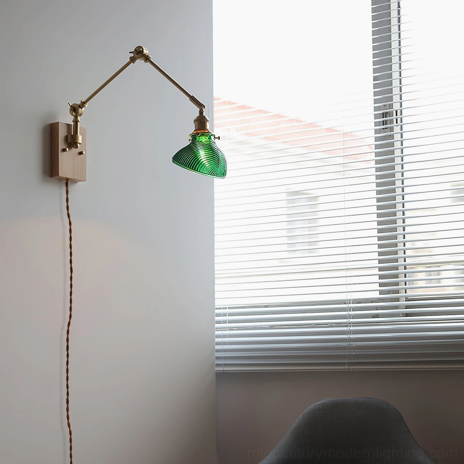 Rebell plug-in swing arm wall lamp with light wood base and green ribbed glass shade, front view in home with window blinds