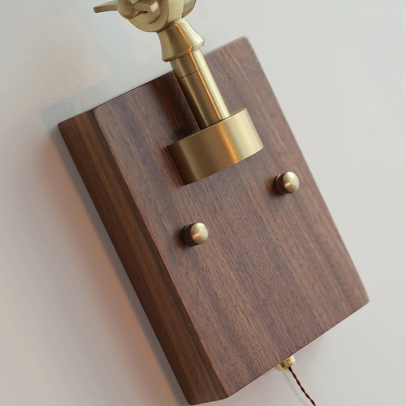 Rebell wall lamp mounting base top-down view showing solid wood plate and brass mounting hardware on white background