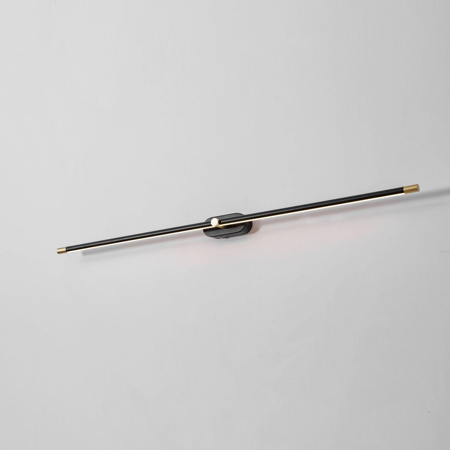 Rechargeable linear wall lamp installed as reading light in modern bedroom accent arrangement