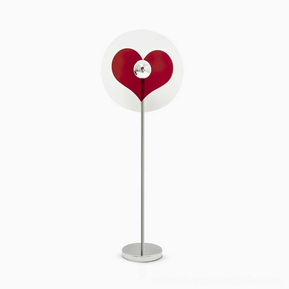 Red heart projection floor lamp with chrome metal pole on white studio background, showing clear acrylic shade with heart cutout detail