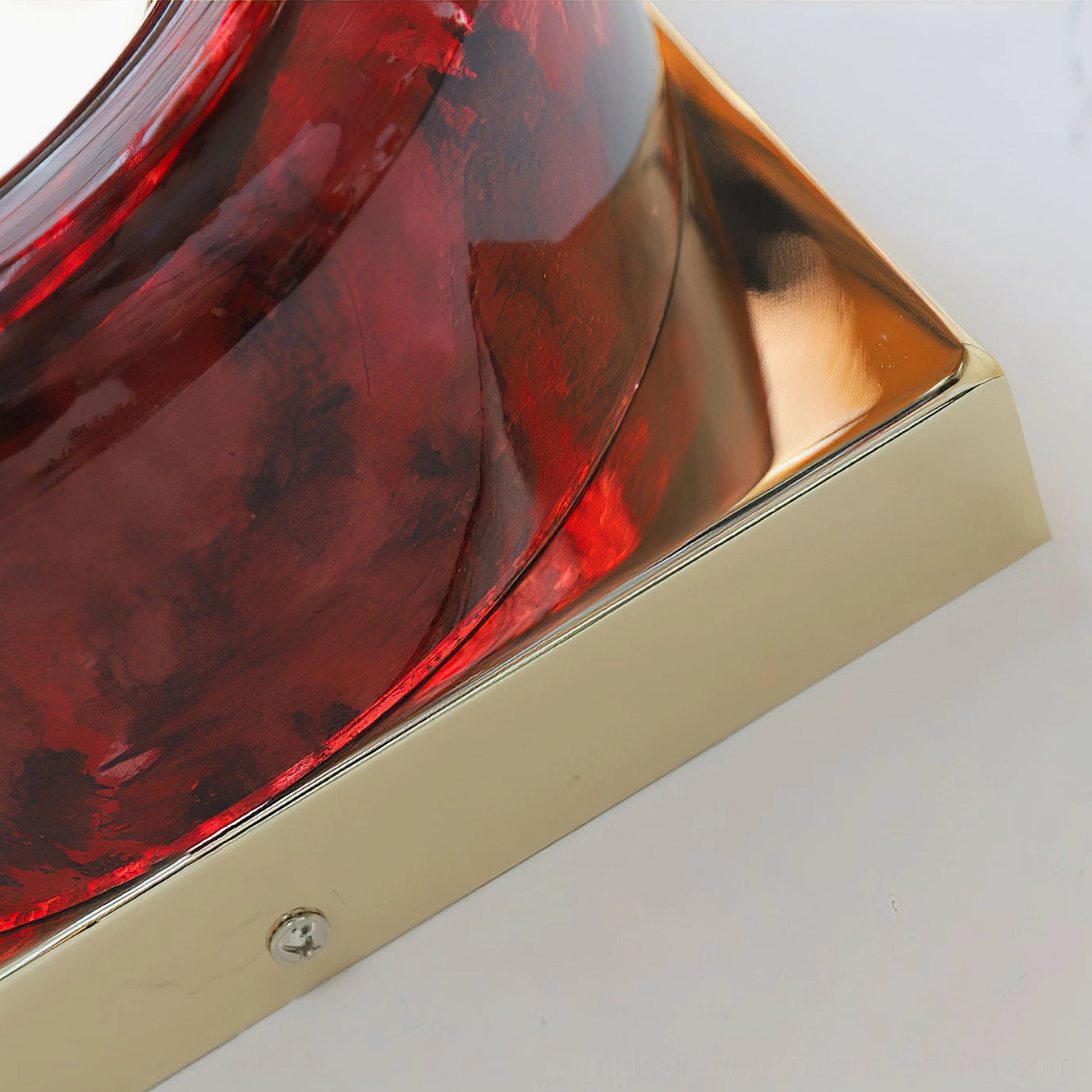 Single red circular sconce providing ambient lighting in minimalist bedroom nook