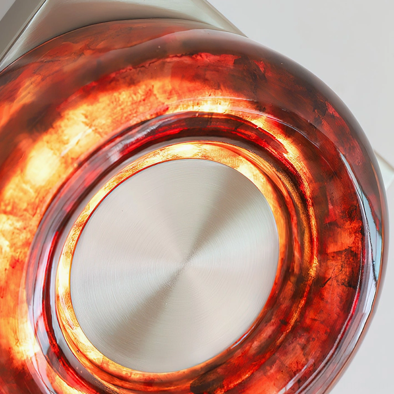 Red circular wall sconce with gold metal finish accent in modern mid-century interior